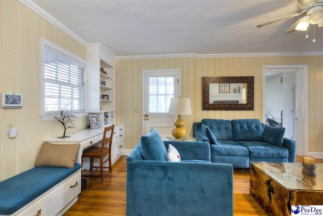 living room with wood finished floors, a wealth of natural light, and crown molding