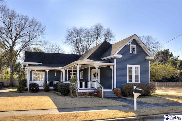 view of front facade featuring covered porch and fence