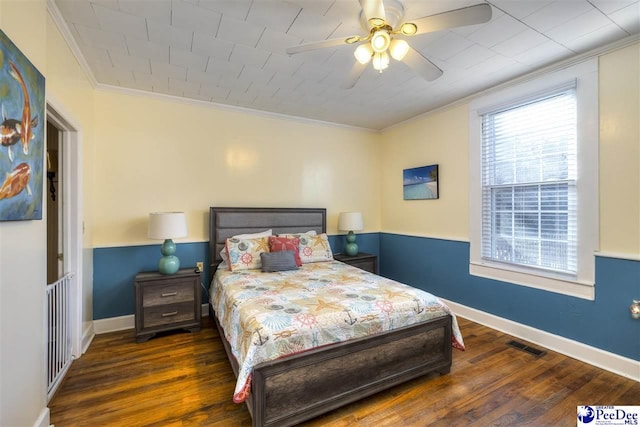 bedroom featuring ceiling fan, wood finished floors, visible vents, baseboards, and ornamental molding