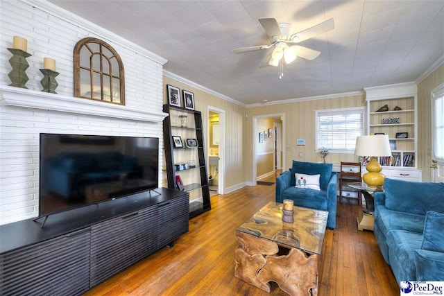 living area featuring ornamental molding, wood finished floors, and a ceiling fan