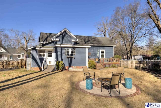 rear view of house featuring an outdoor fire pit, fence, a lawn, and a wooden deck