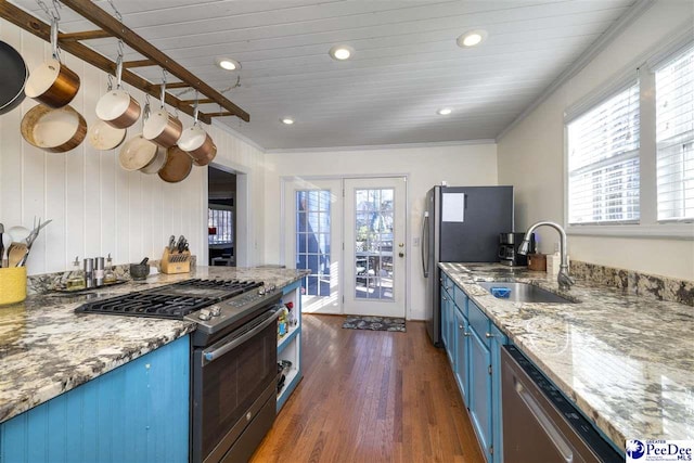 kitchen featuring dark wood-type flooring, stainless steel appliances, crown molding, blue cabinetry, and a sink