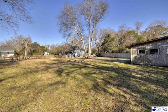 view of yard featuring an outdoor structure and fence