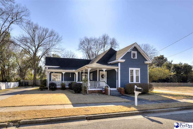 view of front of property featuring a porch and fence