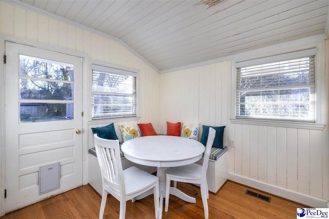 dining area featuring light wood finished floors, visible vents, lofted ceiling, wooden ceiling, and breakfast area