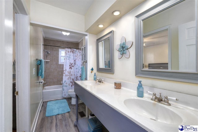 full bathroom featuring toilet, shower / bath combo with shower curtain, a sink, and wood finished floors