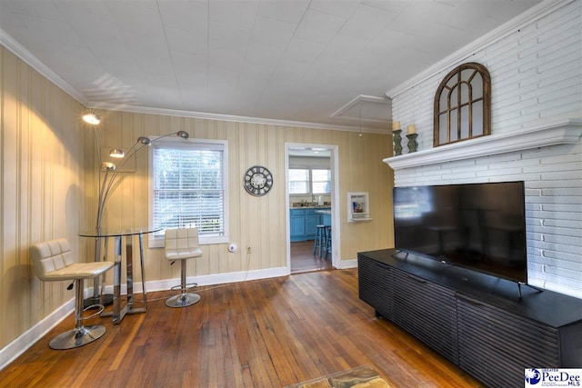 sitting room with baseboards, hardwood / wood-style flooring, attic access, and crown molding