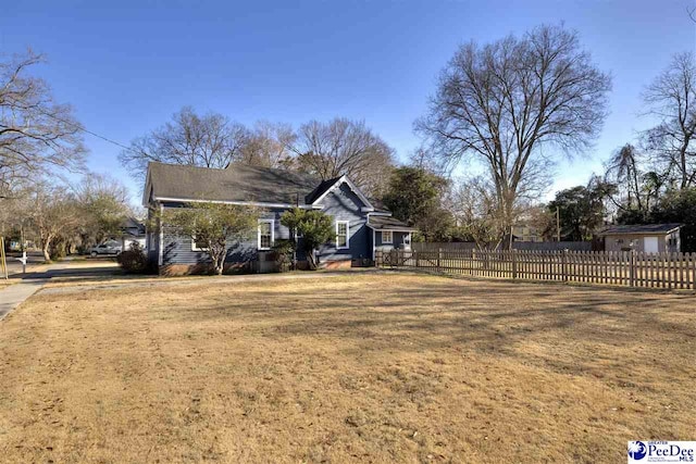 view of side of home featuring a yard and fence