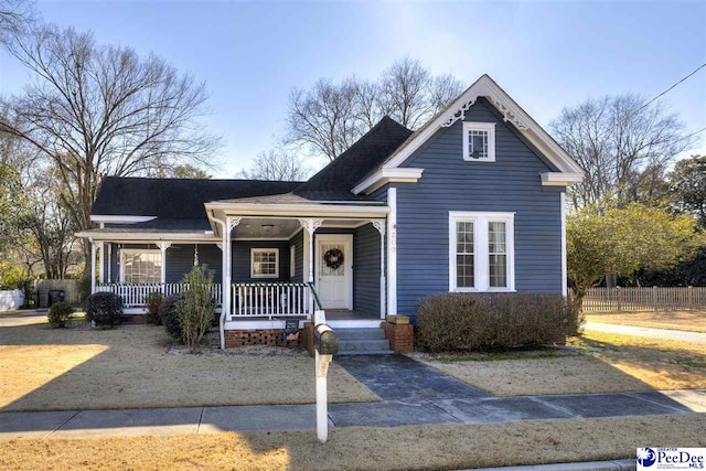 view of front of home with a porch and fence