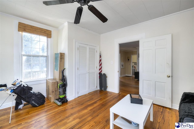 interior space featuring crown molding, baseboards, and wood finished floors