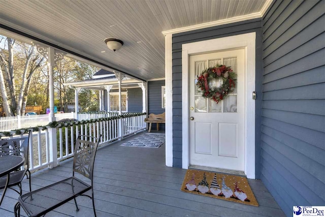 entrance to property featuring fence and a porch