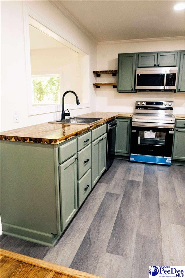 306 Mimosa Dr, Cheraw, SC 29520 - kitchen with green cabinets, appliances with stainless steel finishes, butcher block countertops, open shelves, and crown molding