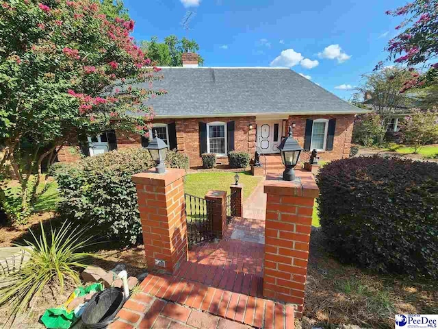 129 Golf Course Rd, Hartsville, SC 29550 - view of front facade featuring a chimney, a shingled roof, and brick siding