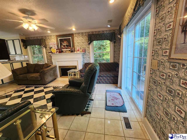 129 Golf Course Rd, Hartsville, SC 29550 - living area featuring wallpapered walls, a ceiling fan, a fireplace with raised hearth, light tile patterned floors, and crown molding
