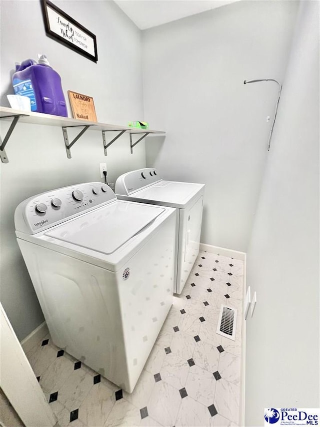 clothes washing area featuring visible vents, baseboards, independent washer and dryer, and laundry area