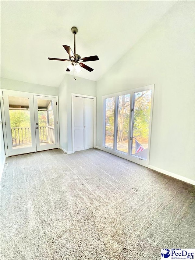 interior space with a ceiling fan, carpet, baseboards, lofted ceiling, and french doors