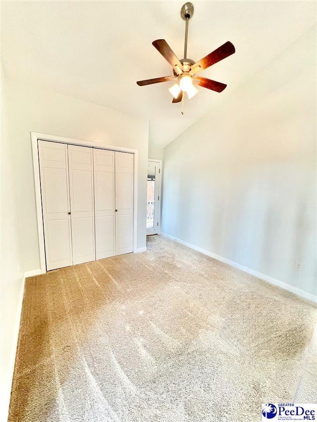 unfurnished bedroom with vaulted ceiling, carpet, baseboards, and a closet