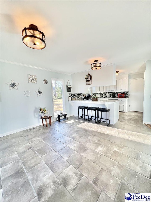 interior space with stone finish floor, baseboards, and ornamental molding