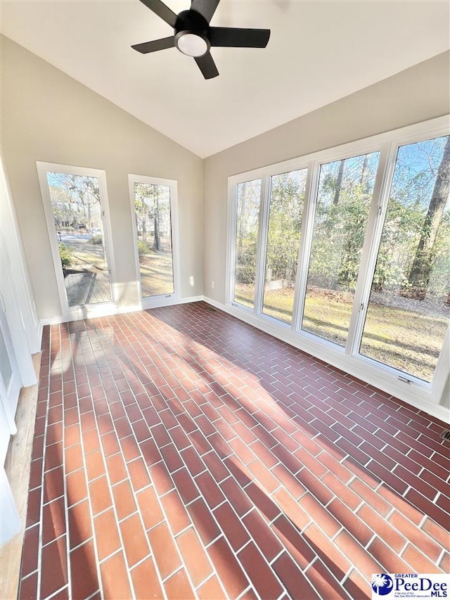 unfurnished sunroom with a healthy amount of sunlight, ceiling fan, and vaulted ceiling