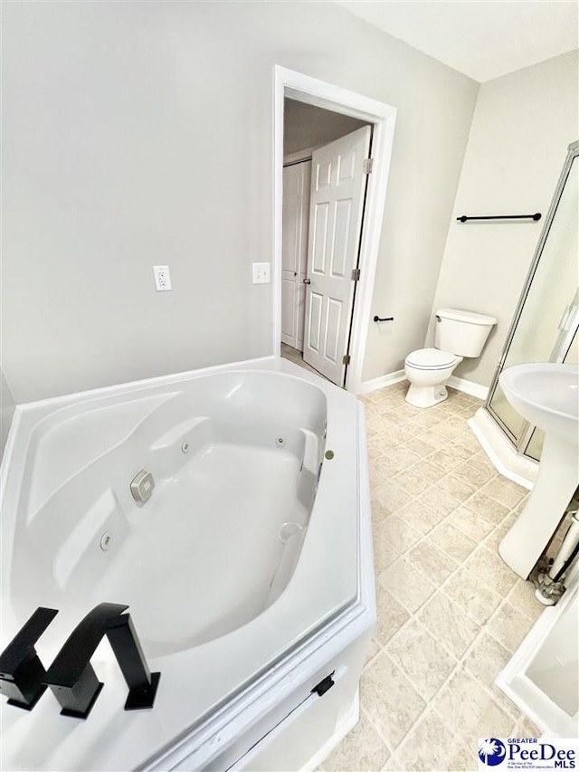 bathroom with baseboards, toilet, a jetted tub, and tile patterned flooring