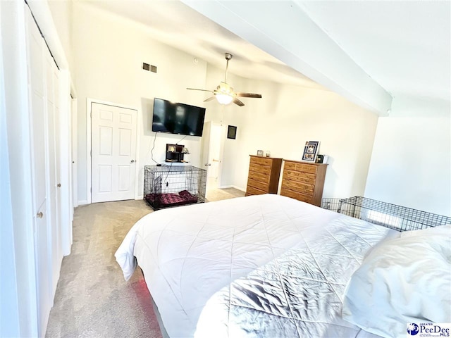 bedroom featuring a closet, visible vents, carpet flooring, and high vaulted ceiling