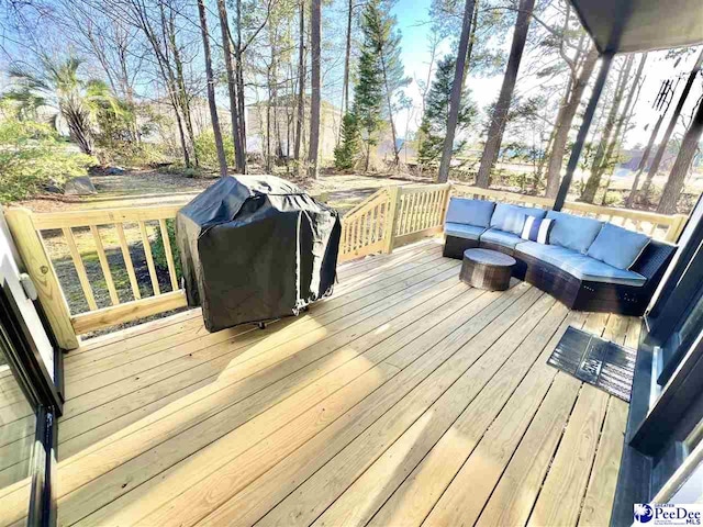 wooden terrace with area for grilling and an outdoor living space