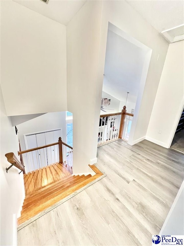 stairway with baseboards and wood finished floors