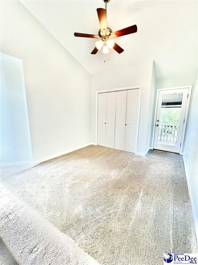 unfurnished bedroom featuring baseboards, lofted ceiling, ceiling fan, a closet, and carpet flooring