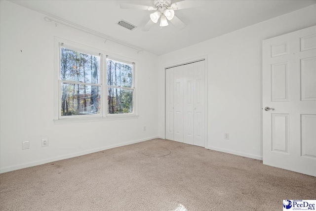 unfurnished bedroom featuring a closet, visible vents, baseboards, and carpet flooring