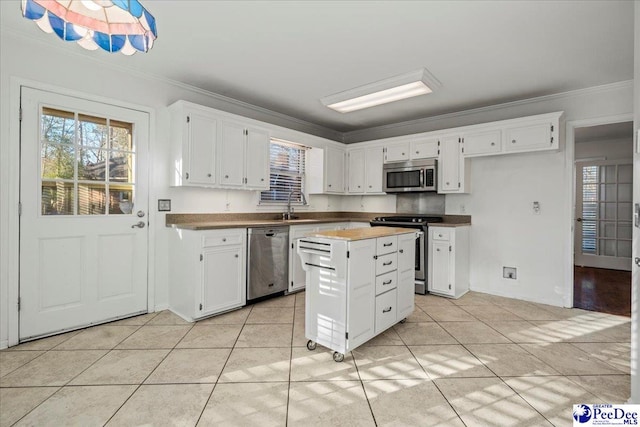 kitchen with stainless steel appliances, white cabinets, crown molding, and a sink