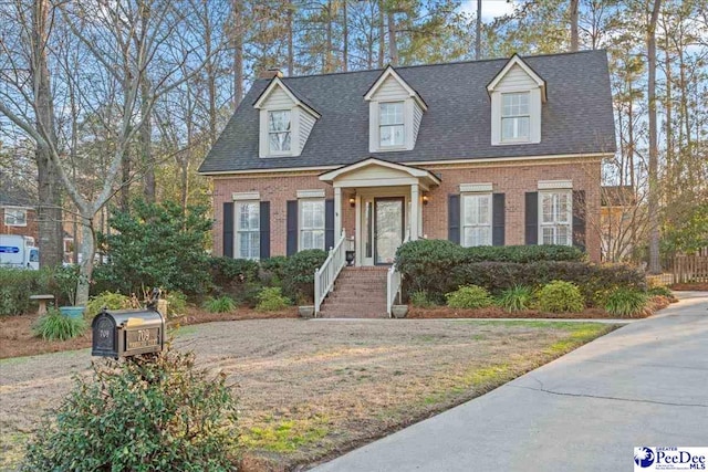 new england style home with brick siding and roof with shingles