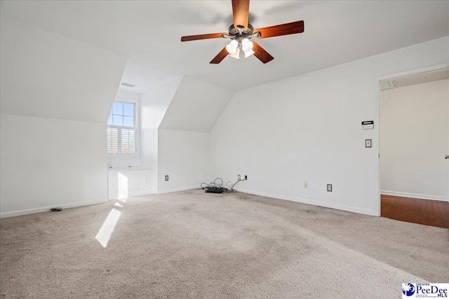 bonus room featuring vaulted ceiling, carpet flooring, a ceiling fan, and baseboards