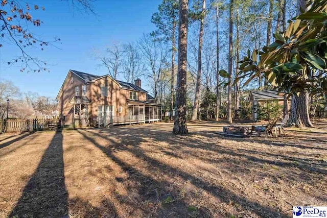 view of side of property featuring a sunroom and fence