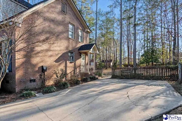 view of home's exterior with fence and brick siding