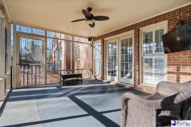 unfurnished sunroom with plenty of natural light and a ceiling fan