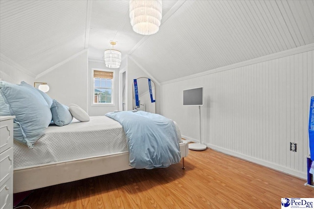 bedroom with wood-type flooring, ornamental molding, and vaulted ceiling