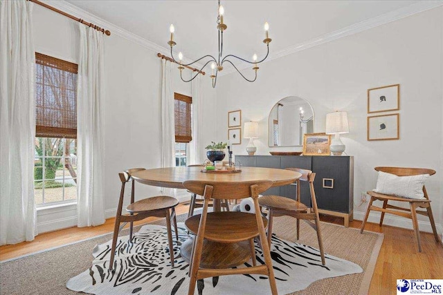 dining area with an inviting chandelier, ornamental molding, and light hardwood / wood-style floors