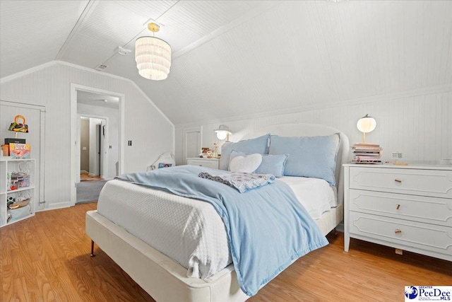 bedroom with vaulted ceiling and light wood-type flooring