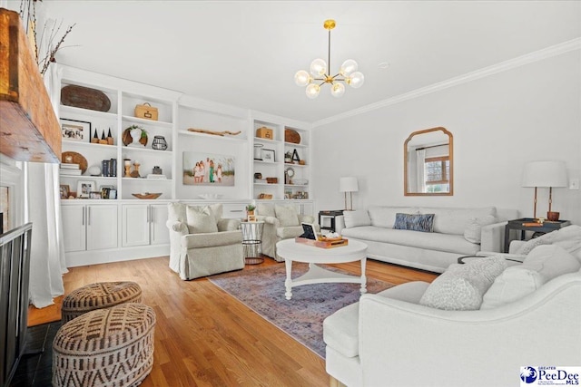 living room with crown molding, a chandelier, built in features, and light wood-type flooring