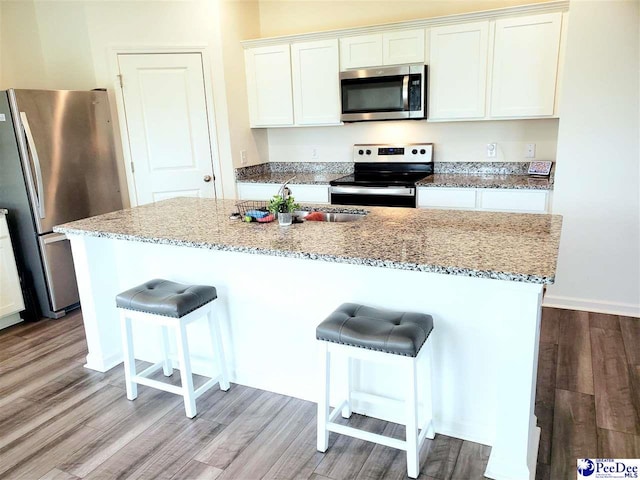 583 Polaris Way, Summerville, SC 29486 - kitchen featuring stainless steel appliances, light wood-style flooring, a kitchen bar, and light stone countertops