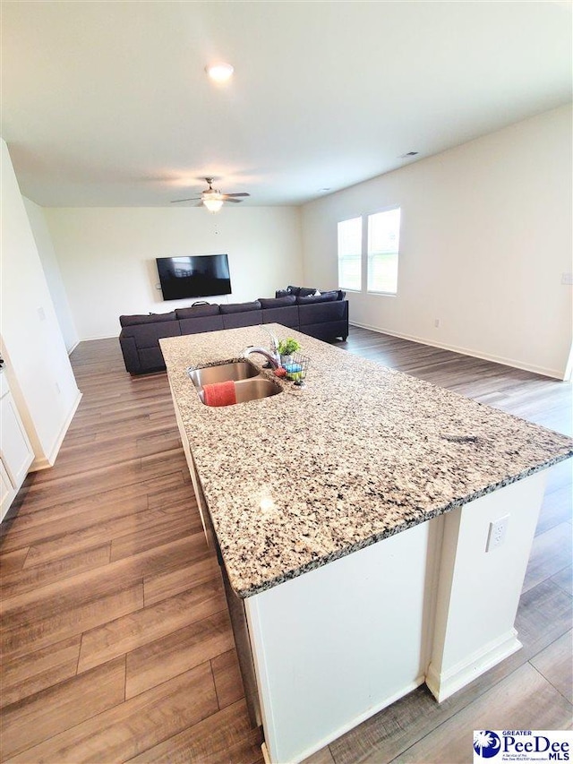 583 Polaris Way, Summerville, SC 29486 - kitchen with a sink, ceiling fan, wood finished floors, light stone countertops, and a center island with sink