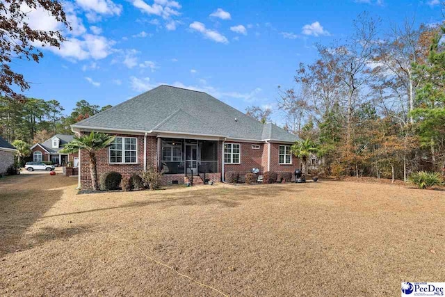 view of front of property with a sunroom and a front yard