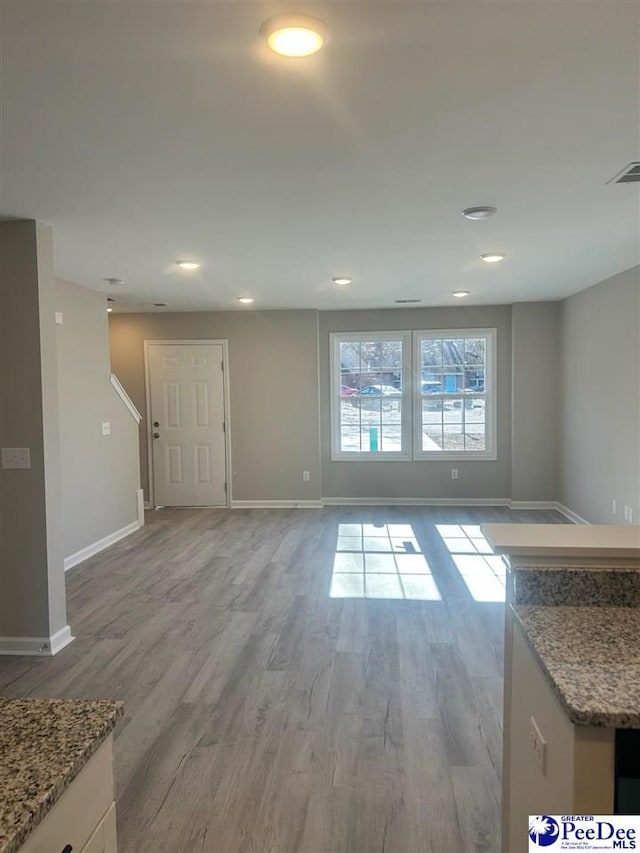 1001/1003 Jessamine Trl, Sumter, SC 29150 - unfurnished living room featuring baseboards, light wood-type flooring, and recessed lighting