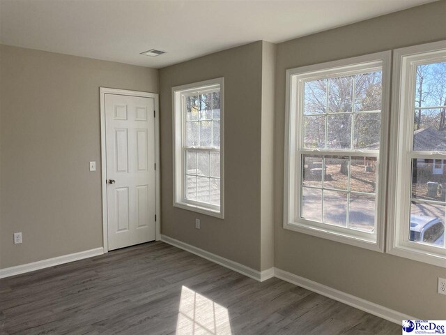 1001/1003 Jessamine Trl, Sumter, SC 29150 - empty room with dark wood-style flooring, baseboards, and healthy amount of natural light