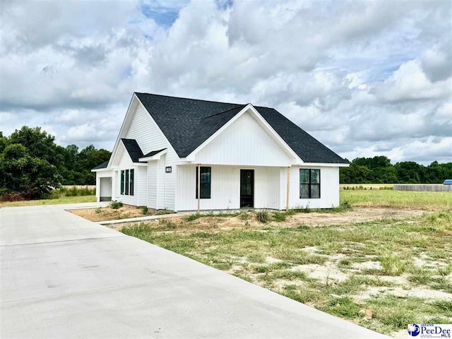 945 Brickhouse Rd, Florence, SC 29506 - modern inspired farmhouse with driveway, roof with shingles, a porch, and a garage