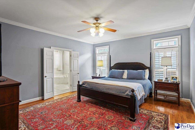 2543 Ben Hogan Cir, Florence, SC 29506 - bedroom featuring ornamental molding, baseboards, ensuite bath, ceiling fan, and wood finished floors