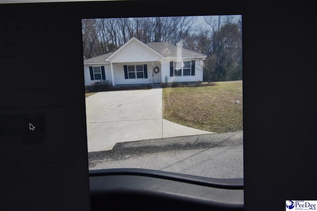 view of front of property with concrete driveway and a front lawn