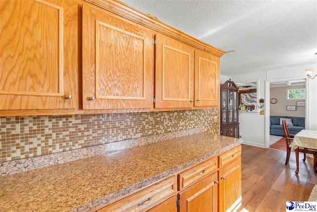 3518 Leigh Ln, Florence, SC 29505 - kitchen with decorative backsplash, dark wood finished floors, a textured ceiling, baseboards, and light stone countertops