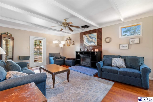 3518 Leigh Ln, Florence, SC 29505 - living area featuring wood finished floors, beamed ceiling, ceiling fan, and a brick fireplace