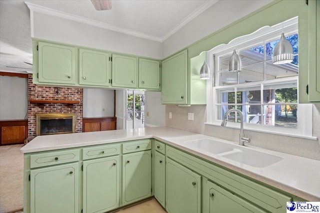 kitchen featuring sink, ornamental molding, kitchen peninsula, and green cabinets